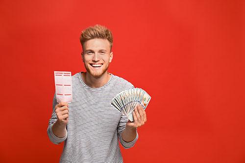 Man with money and lottery ticket